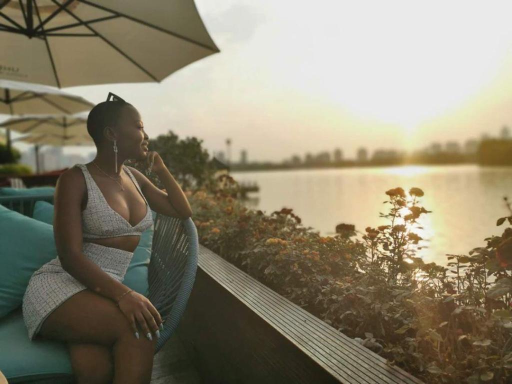 Khanya sittting near water with sunset
