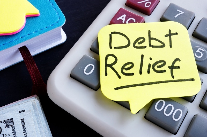 Post note reads debt relief placed on calculaor